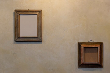 Obraz na płótnie Canvas empty picture frames on a wall with rough plaster