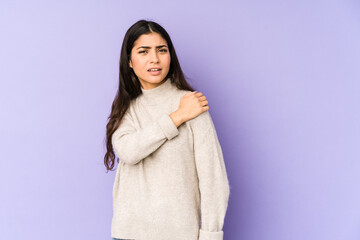 Young indian woman isolated on purple background having a shoulder pain.