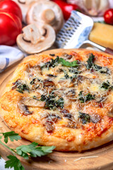 Homemade pizza with mozzarella, mushrooms and spinach.