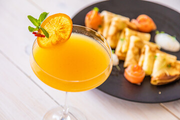 orange cocktail on a white background. decorated with a slice of dry orange