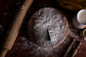 Homemade banana or plantain cake portioned in a circular shape sprinkled with glass sugar overhead plane © Diego