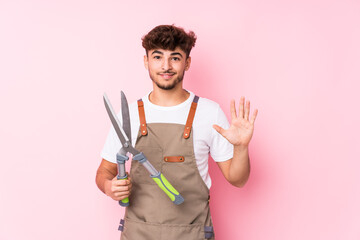 Young arab gardener man isolated smiling cheerful showing number five with fingers.