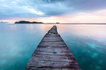 Old wooden pier in Indian ocean. Tropic island. Tranquil sunset landscape 