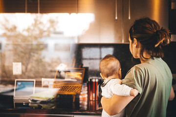 A woman with a baby is standing in a old house, California