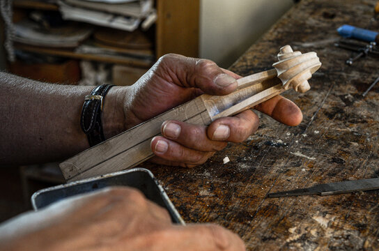 Violin maker luthier hand working a new violin scroll in Cremona Italy