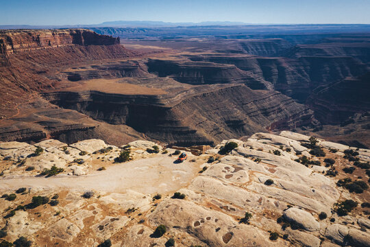 Aerial view of a car on a cliff of a Utah canyon