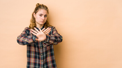 Young caucasian woman isolated on beige background doing a denial gesture