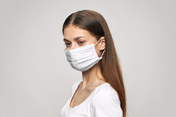 Girl with a medical mask on her face and in a white T-shirt 