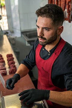 butcher Making raw beef burgers in Butchers shop.