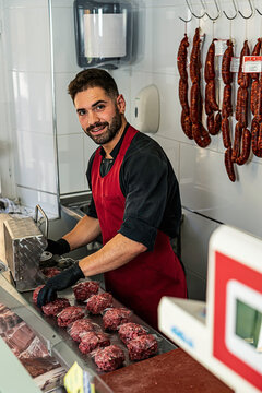 butcher Making raw beef burgers in Butchers shop.