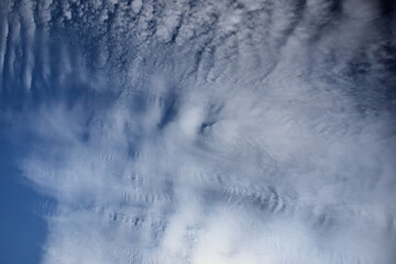 blue sky covered by a sheet of white clouds stirred by the winds.