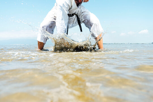karate man punches the water with his fist
