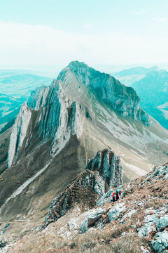 Two female climbers ascending steep grass couloir in Swiss Alps