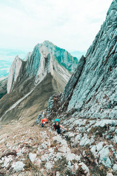 Two young female climber ascending steep mountain face in Switzerland