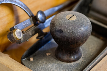 Antique wood plane covered with dust in a wood shop