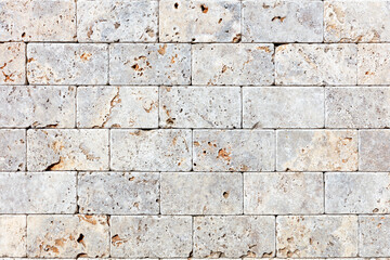 The wall is clad in hewn gray shell rock, texture and background.