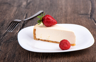 Slice of cheesecake with strawberries on a white plate.