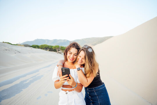 Young women with mobile phones are excited and happy