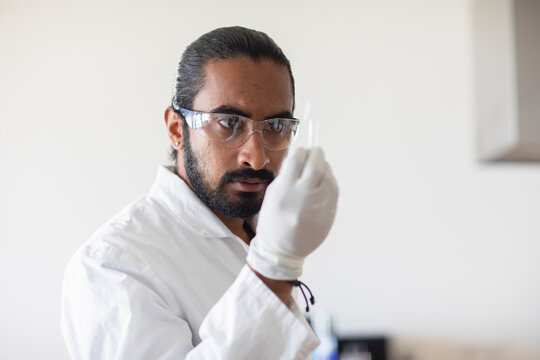 young man scientist  with lab coat checking a sample