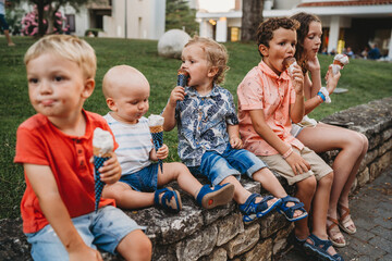 Boys and girls eating ice cream together during summer holidays