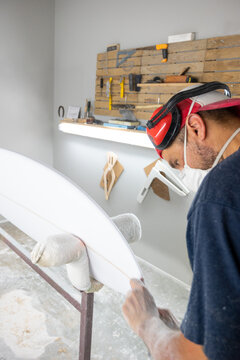 Surfboard Modeling Workshop - Man perfecting the modeling of a surfboard