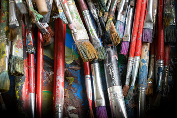 Obraz premium A lot dirty artist paint brushes in a bucket