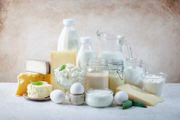 Fresh dairy products, milk, cottage cheese, eggs, yogurt, sour cream and butter on white table
