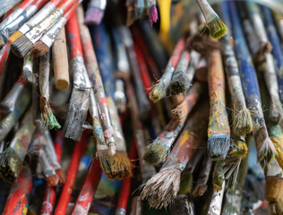 Obraz premium A lot dirty artist paint brushes in a bucket