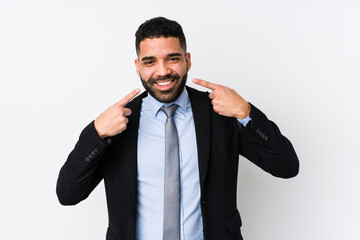 Young latin business woman against a white background isolated smiles, pointing fingers at mouth.