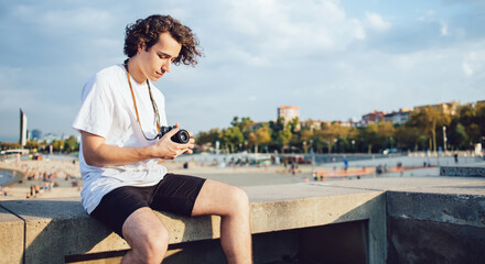 Caucasian tourist adjust settings on modern camera for photographing environment and practicing...