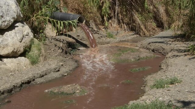 Sewage collector emanating sewage shit at the mouth of a river