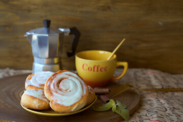 Geyser coffee maker and cinnamon bun on a wooden tray. With coffee cup and spoon. Dark background