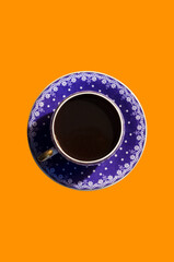 Top view of cup with black morning coffee isolated on orange background. Flat lay.