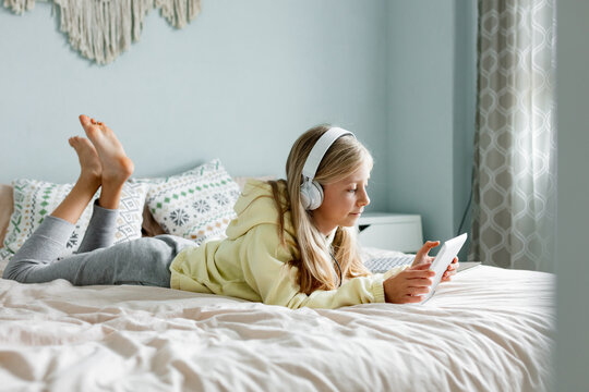 Child using tablet with dog on the bad