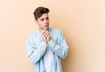 Fototapeta premium Young caucasian man isolated on beige background making up plan in mind, setting up an idea.
