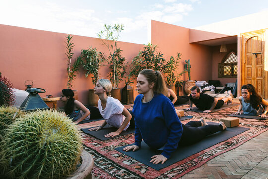 Group of Young People Practicing Yoga on Roof