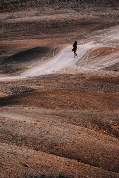 Lonely Woman Walking in Brown Desert