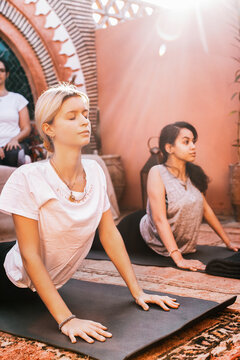 Young Women Practicing Yoga in Sun