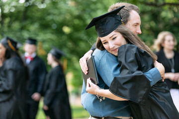 Grad: Proud Parent Hugs New Graduate