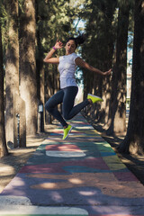 Healthy lifestyle young fitness woman jumping in the park