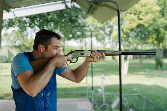 Mid Adult Man Training His Aim and Concentration Using a Shotgun in a Clay Pigeon Shooting Field Sport Centre