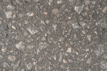 Abstract background of black asphalt with inclusions of pebbles