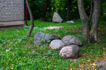 Large granite stone, stones on the green grass in the garden