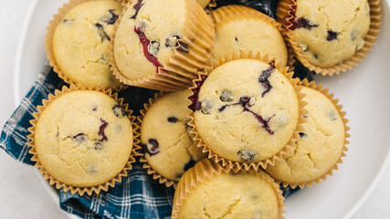 Bunch of blueberry cornbread muffins on a plate with a napkin