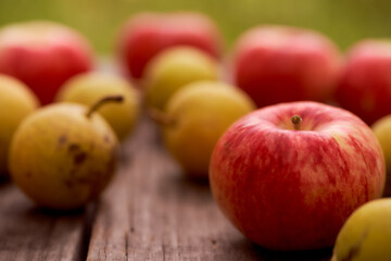 Red apples and small pear lie on a wooden board. Top view.With copy space. Macro effect photo.