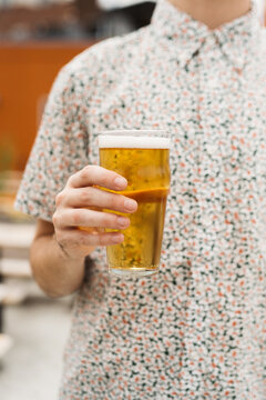 Stylish man holding a pint of beer