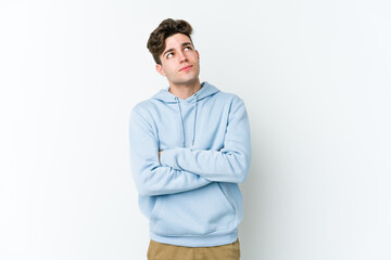 Young caucasian man isolated on white background dreaming of achieving goals and purposes