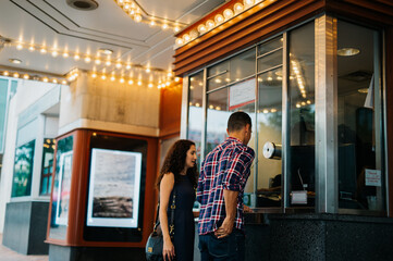 Couple on a date buying movie tickets