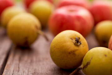 Red apples and small pear lie on a wooden board. Top view.With copy space. Close-up.