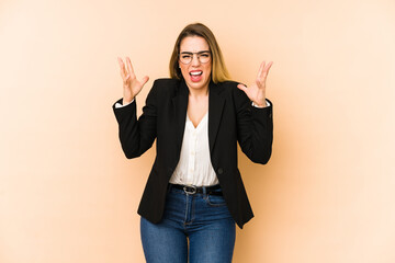 Middle age business woman isolated on beige background screaming with rage.